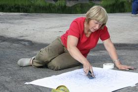 Н. В. Лобанова делает графитную копию петроглифа